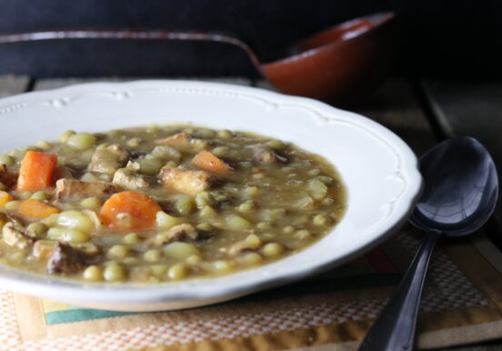 German pea stew, a hearty soup, in a bowl, with a spoon next to it.